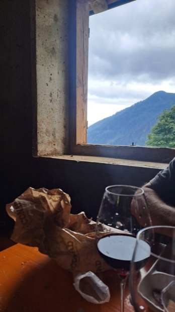 Bicchieri di vino rosso su un tavolo accanto alla finestra della malga
