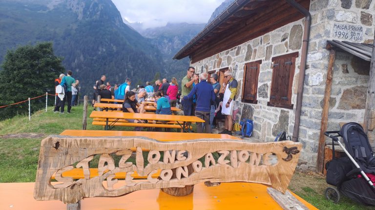 Le tavolate davanti alla malga, con l’insegna della Stazione di Fecondazione in primo piano