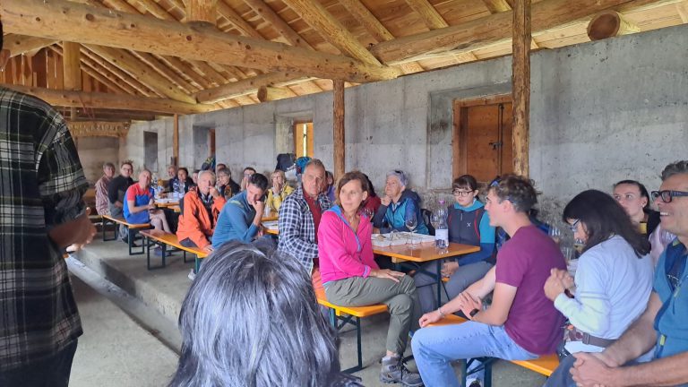 Il pubblico seduto ai tavoli e sulle panche della malga