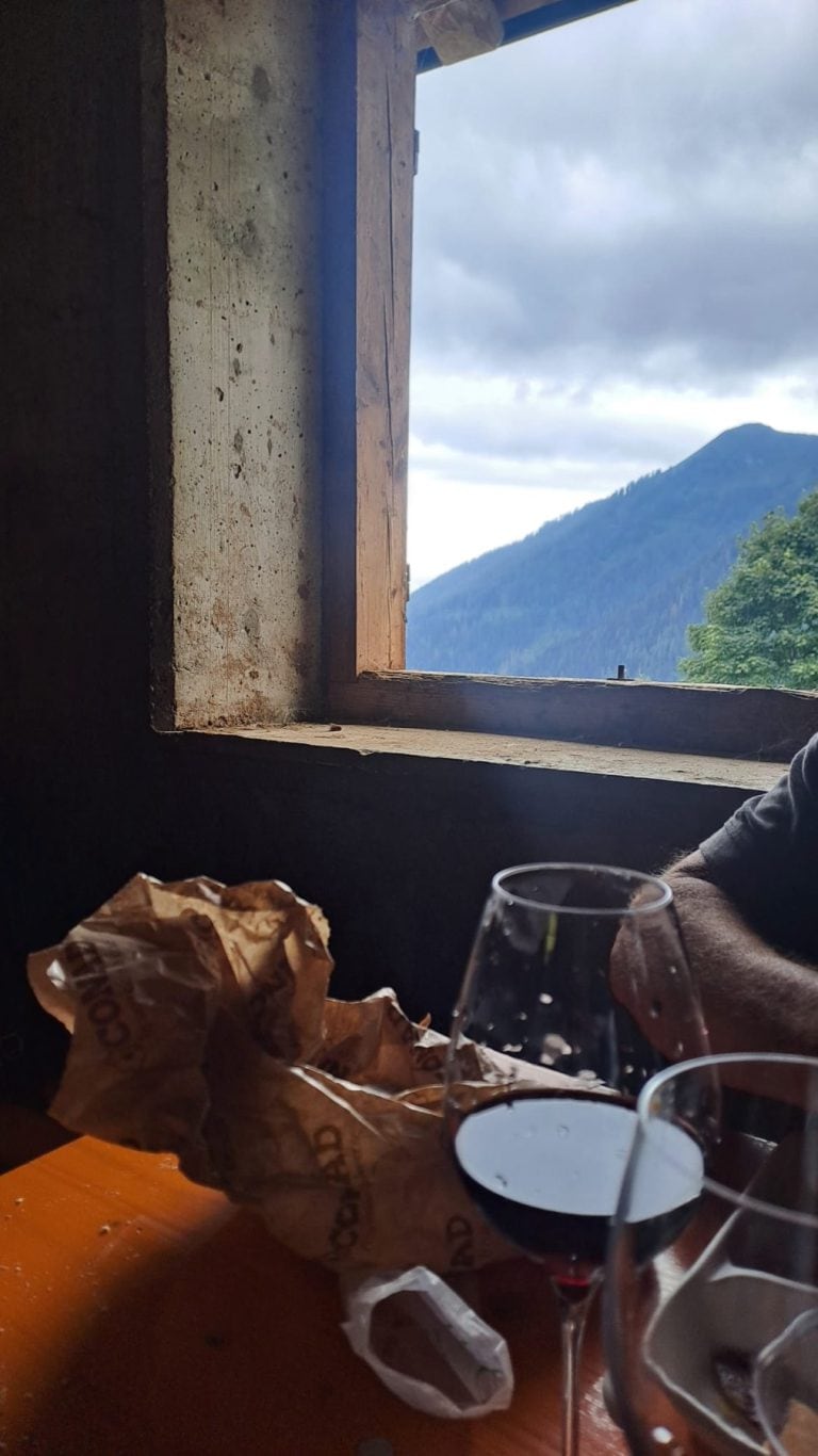 Bicchieri di vino rosso su un tavolo accanto alla finestra della malga