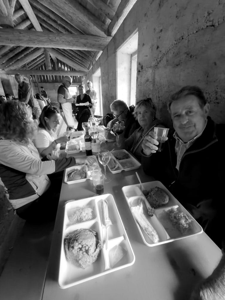 Partecipanti a tavola durante il pranzo, in bianco e nero