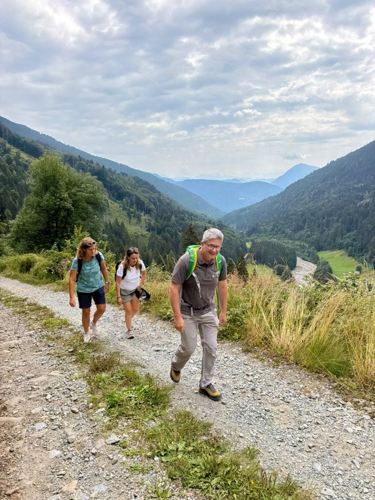 Partecipanti in cammino sulla strada forestale verso Malga Praino