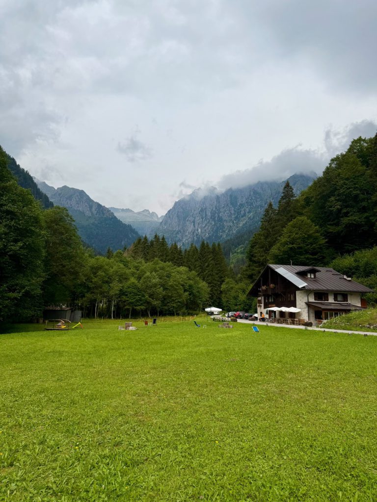 Il prato e il rifugio a fondovalle, punto di partenza della camminata